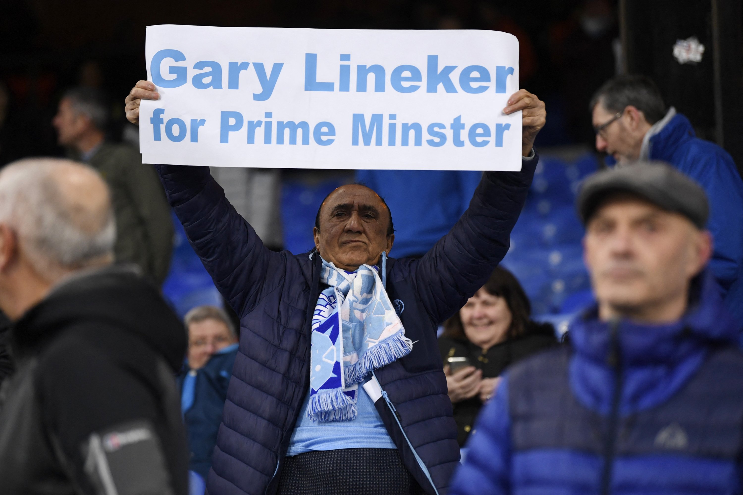 Seorang penggemar Man City mengangkat tanda dukungan untuk presenter BBC Gary Lineker sebelum pertandingan Liga Inggris melawan Crystal Palace, London, Inggris, 11 Maret 2023. (Foto Reuters)
