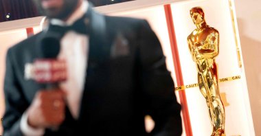 A member of the media speaks to camera near a decorative Oscar statue as final preparations are made for the 95th Academy Awards, in Hollywood, Los Angeles, California, U.S., March 11, 2023. (AFP Photo)