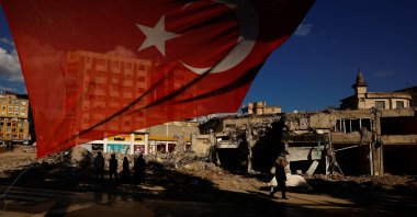 A Turkish flag flies next to damaged buildings in the aftermath of a deadly earthquake in Kahramanmaraş, Türkiye, March 9, 2023. (Reuters Photo)