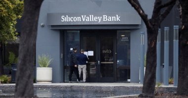 A man puts a sign on the door of the Silicon Valley Bank as an onlooker watches at the bank’s headquarters in Santa Clara, California, U.S. March 10, 2023. (Reuters Photo)