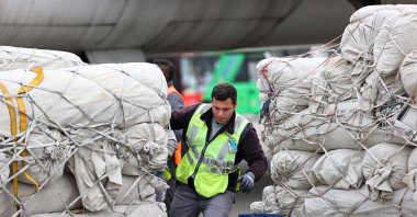An airport worker pushes a crate of humanitarian aid that arrived from Pakistan for earthquake victims in Adana, Türkiye, March 12, 2023. (AA Photo)