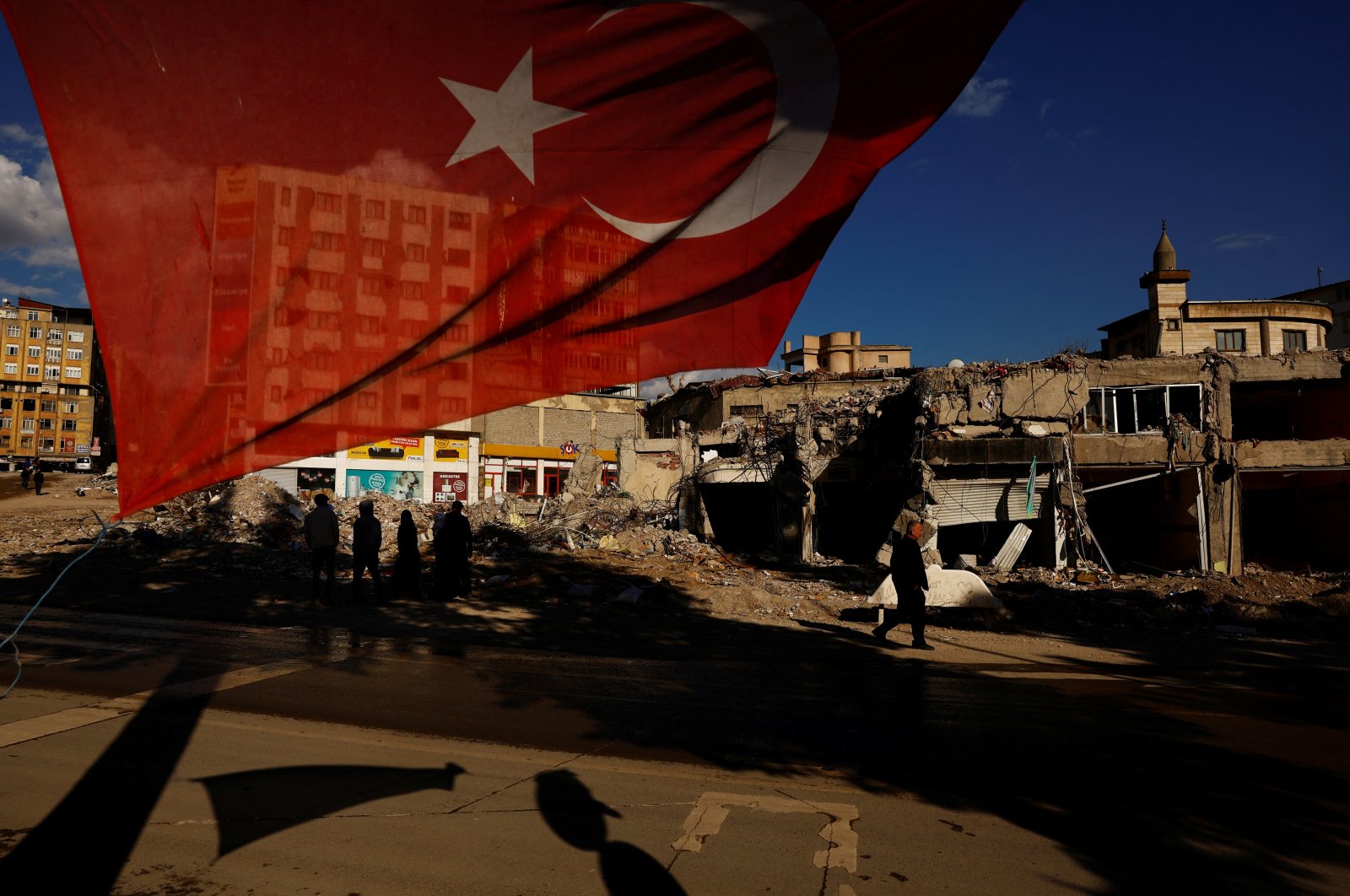 A Turkish flag flies next to damaged buildings in the aftermath of a deadly earthquake in Kahramanmaraş, Türkiye, March 9, 2023. (Reuters Photo)