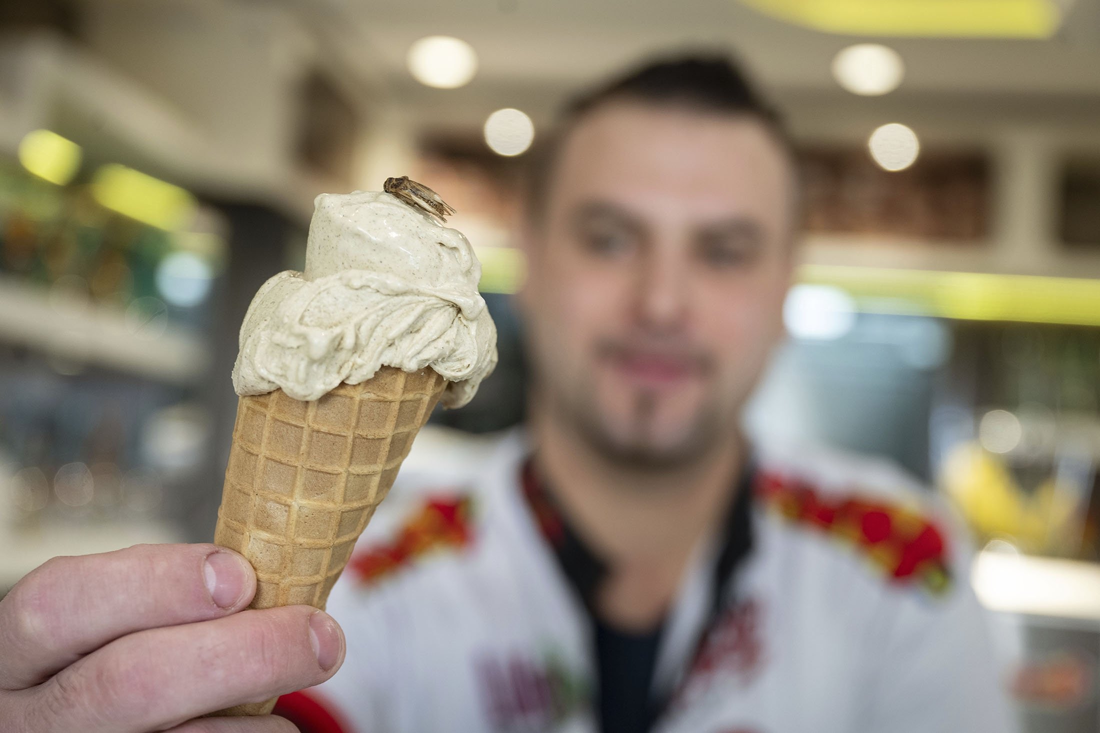 Thomas Micolino, owner of Eiscafe Rino, holds an ice cream cone in Rottenburg am Neckar, Germany, March 1, 2023. (AP Photo)
