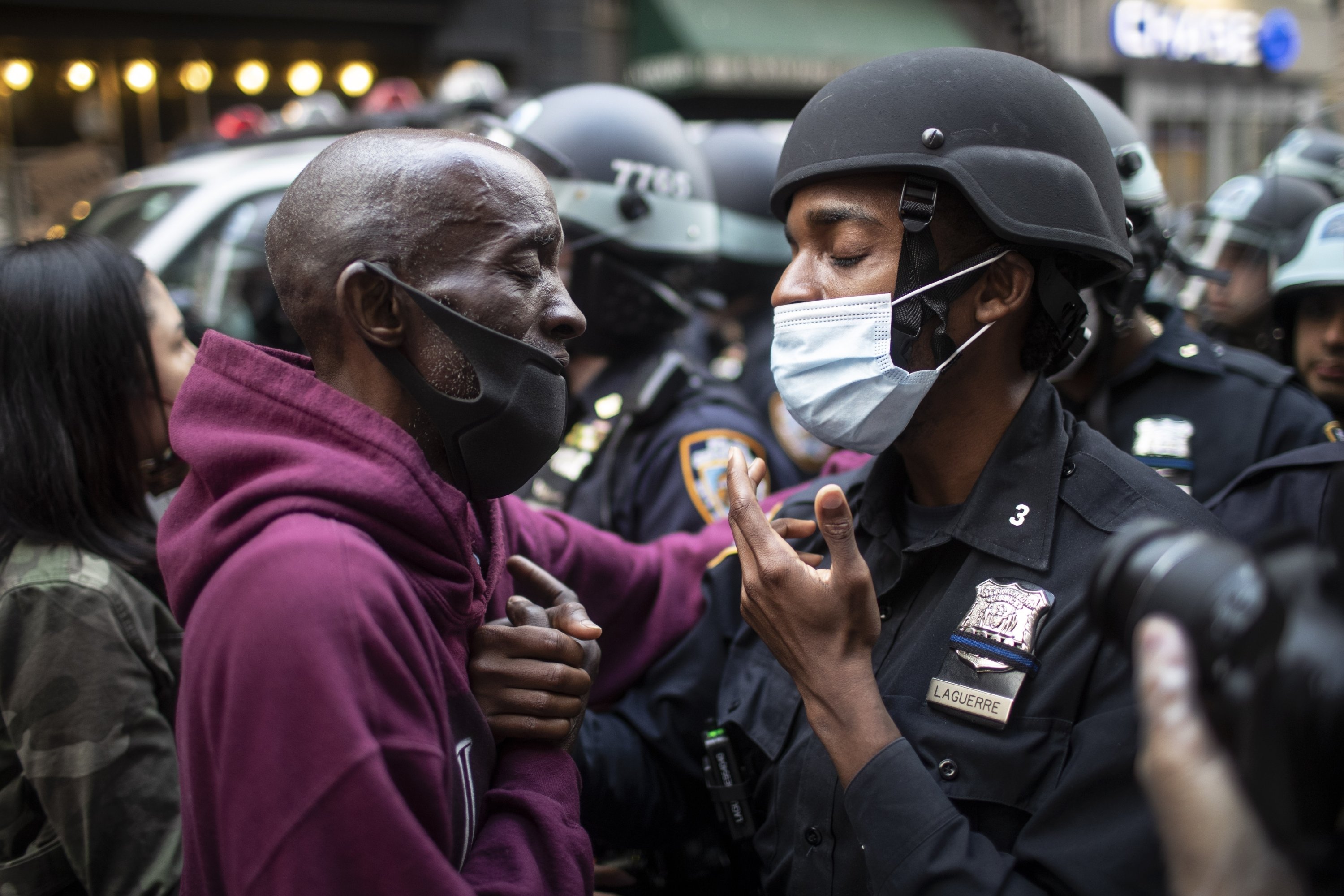 Seorang pengunjuk rasa dan seorang petugas polisi menyapa di tengah kebuntuan di New York, AS, 2 Juni 2020. (Foto AP)