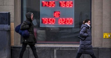 Pedestrians walk past a board at a currency exchange office in Moscow, Russia, Feb. 16, 2023. (AFP Photo)