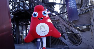 A mascot of the Paris 2024 Paralympic Games poses at the Eiffel Tower after a news conference on ticket sales for the Paris 2024 Olympic Games, Paris, France, Nov. 28, 2022. (Getty Images Photo)