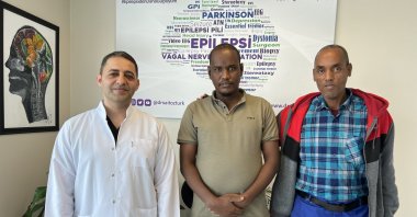 Djiboutian patient Mahad Ahmed Houssein (C) poses with Dr. Said Öztürk after undergoing surgery for a brain battery to treat his epilepsy in Istanbul, Türkiye, (IHA Photo)