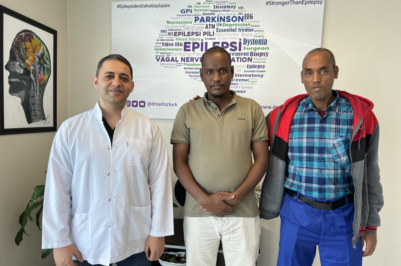 Djiboutian patient Mahad Ahmed Houssein (C) poses with Dr. Said Öztürk after undergoing surgery for a brain battery to treat his epilepsy in Istanbul, Türkiye, (IHA Photo)