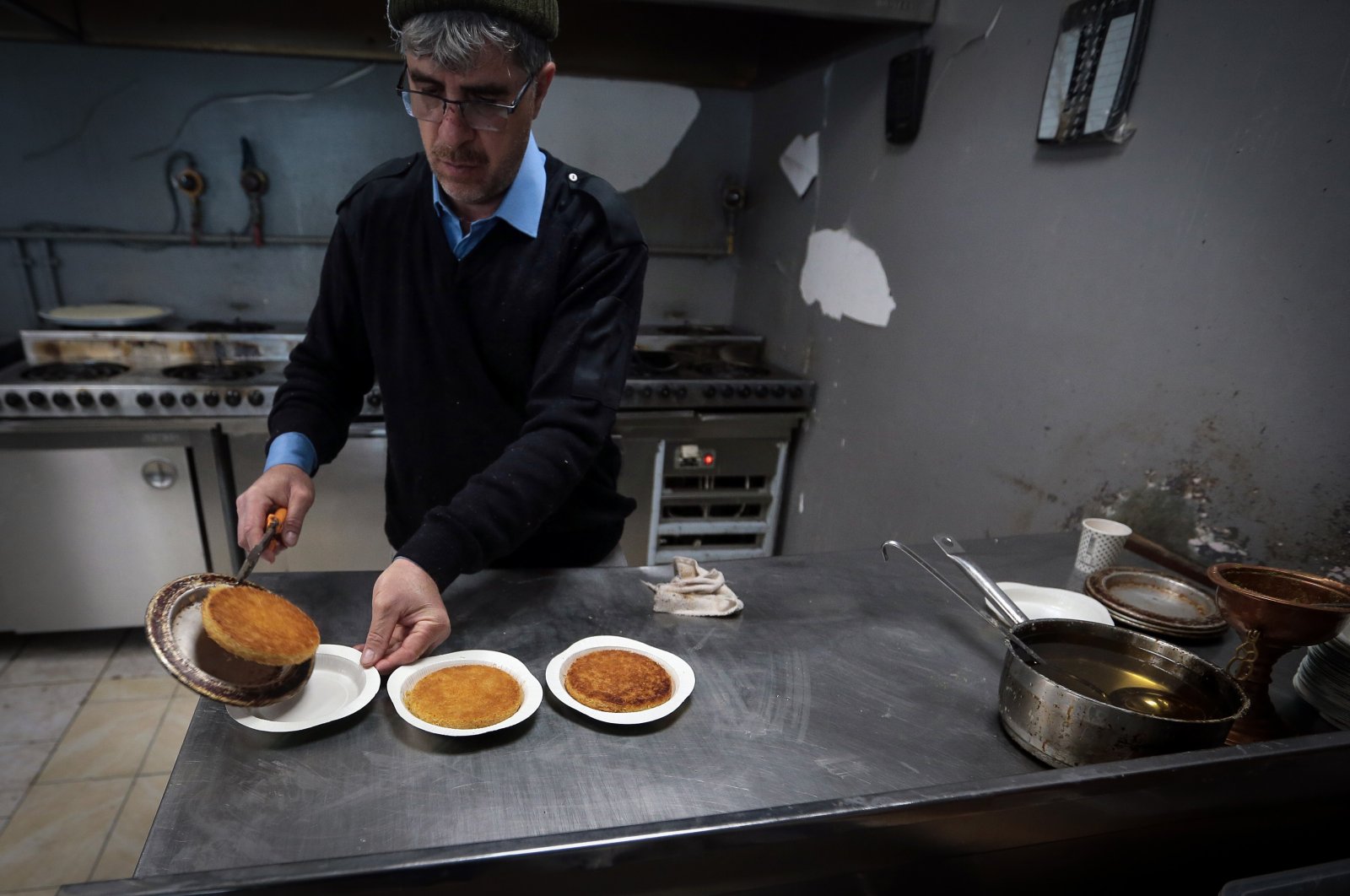 A man prepares the famous Antakya Künefe at the künefe shop in Derince Mahallesi, March 12, 2023 (AA photo)