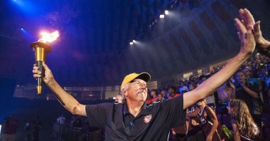The late Olympian Dick Fosbury greets fans while carrying the torch to kick off the Commonwealth Games at the Vines Center, in Lynchburg, Virginia, U.S., July 22, 2016. (AP Photo)