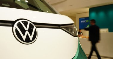 A participant passes by an ID.Buzz Volkswagen car prior to the annual press conference of the automotive group Volkswagen at the Volkswagen Group Forum showroom in Berlin, Germany, March 14, 2023. (EPA Photo)