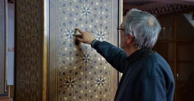 The marquetry artist Adil Fikret Turgaç introduces his designs applied on wall of Körfez Ilimtepe Central Mosque, Kocaeli, Türkiye, March 13, 2023. (IHA Photo)