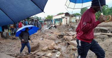 People cross a makeshift bridge over flood waters in Chimkwankhunda in Blantyre, Malawi, March 14, 2023. (AFP Photo)
