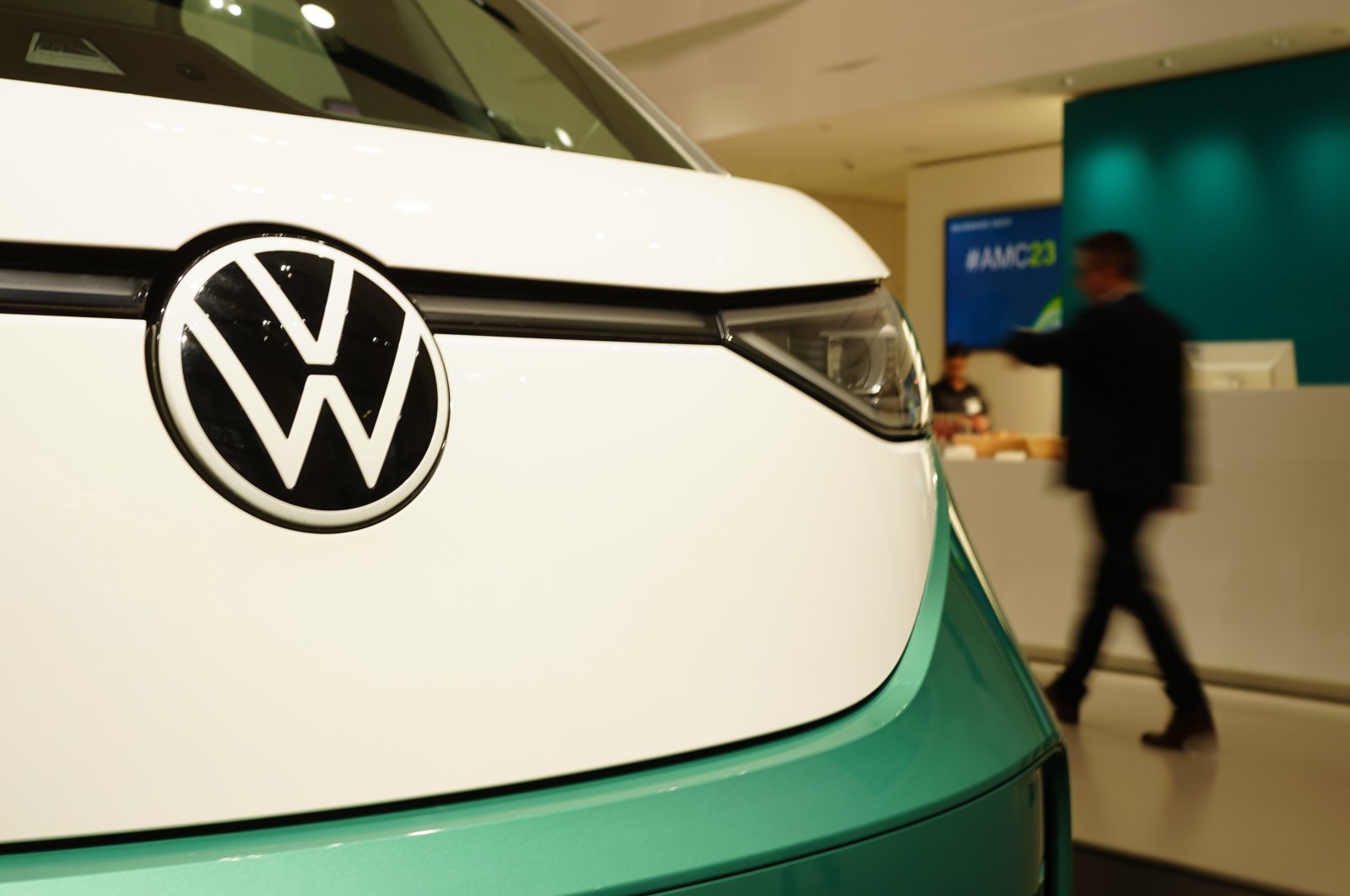 A participant passes by an ID.Buzz Volkswagen car prior to the annual press conference of the automotive group Volkswagen at the Volkswagen Group Forum showroom in Berlin, Germany, March 14, 2023. (EPA Photo)