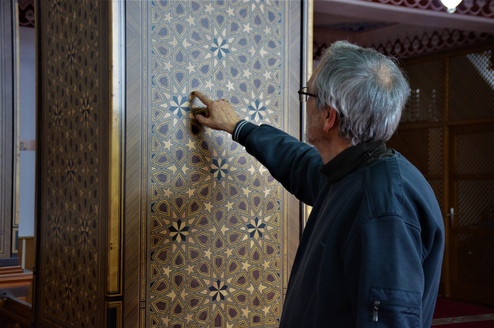 The marquetry artist Adil Fikret Turgaç introduces his designs applied on wall of Körfez Ilimtepe Central Mosque, Kocaeli, Türkiye, March 13, 2023. (IHA Photo)