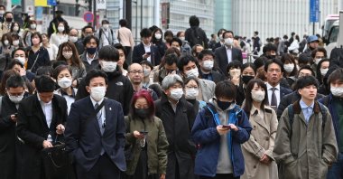 Commuters wait at traffic signal at a crossing in the Shinjuku district of Tokyo, Japan, March 13, 2023. (AFP Photo)