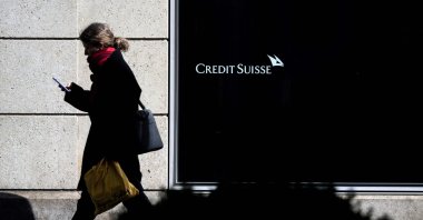A woman is seen in silhouette walking past a branch of Credit Suisse in Vevey, western Switzerland, March 15, 2023. (AFP Photo)