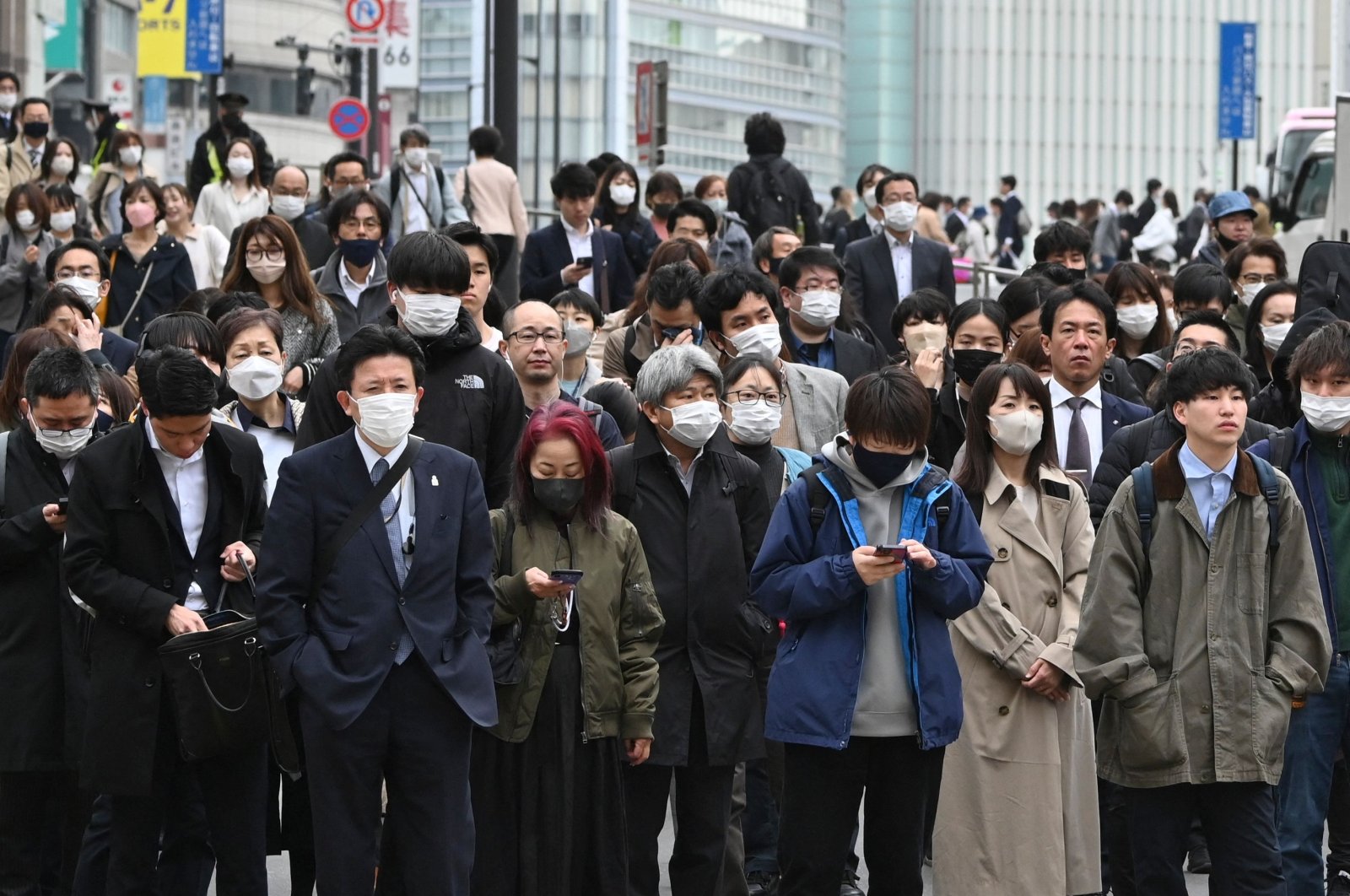 Commuters wait at traffic signal at a crossing in the Shinjuku district of Tokyo, Japan, March 13, 2023. (AFP Photo)