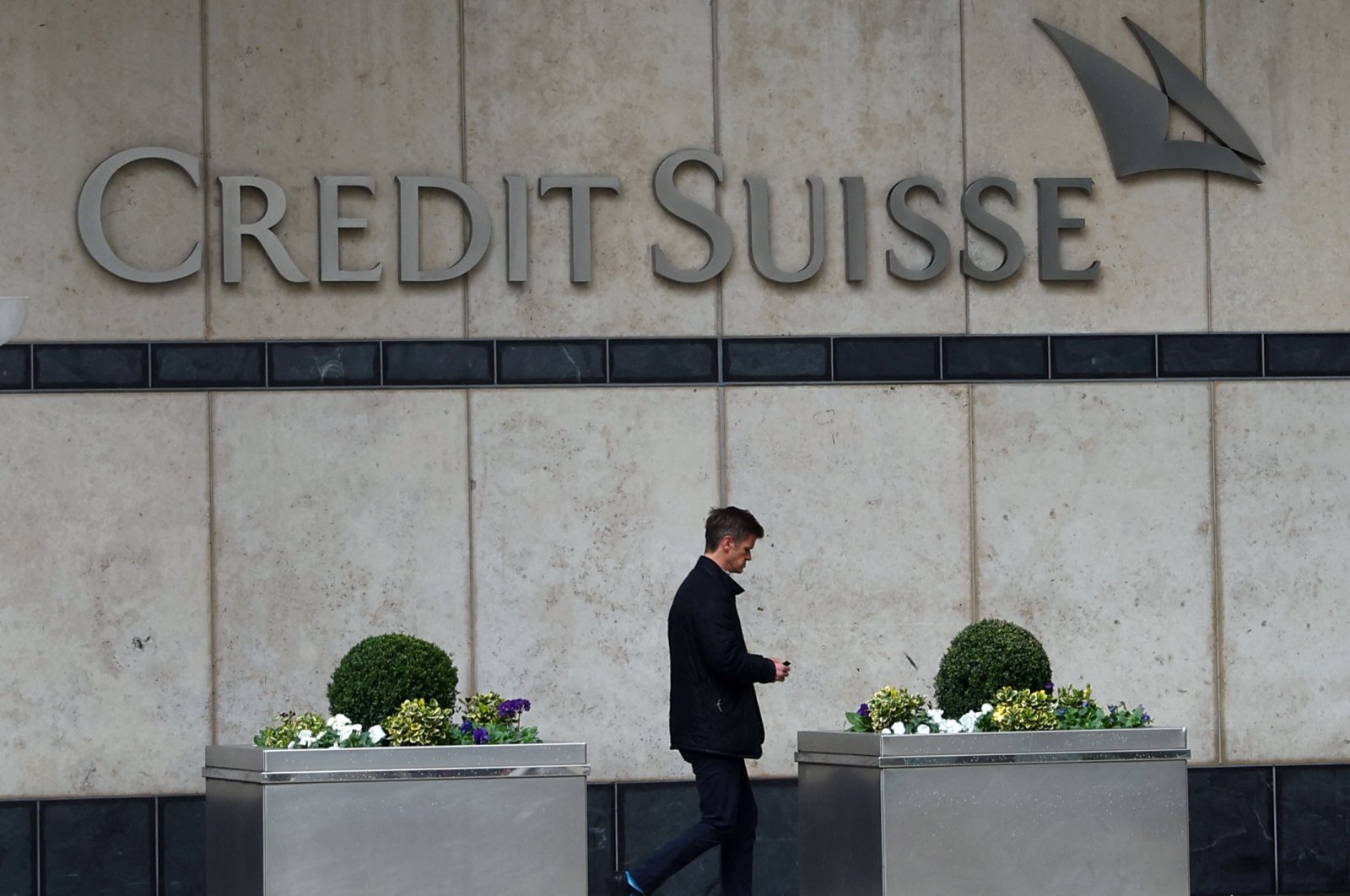 A man walks past the Credit Suisse office in Canary Wharf in London, Britain, March 16, 2023. (Reuters Photo)