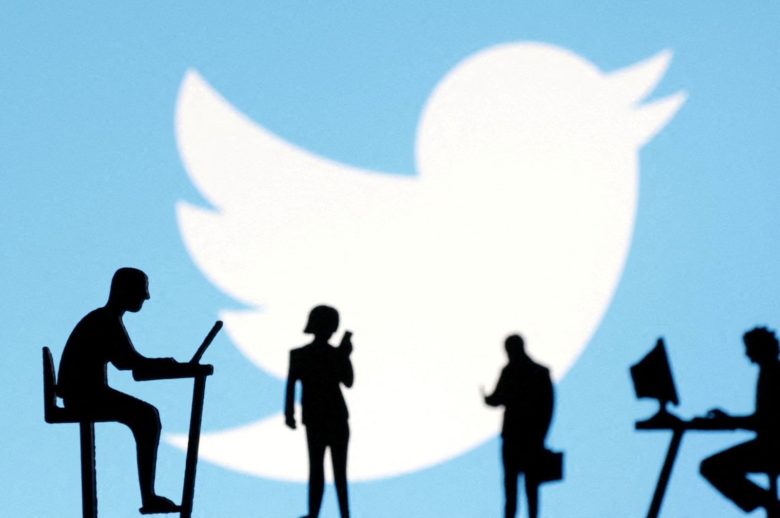 Figurines with smartphones and computers are seen in front of the Twitter logo in this illustration. (Reuters Photo) 
