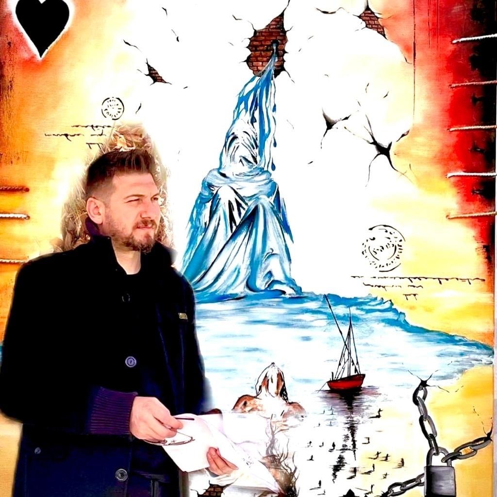 Surrealist painter Vahap Aydoğan stands near his artwork. (Photo courtesy of the artist)