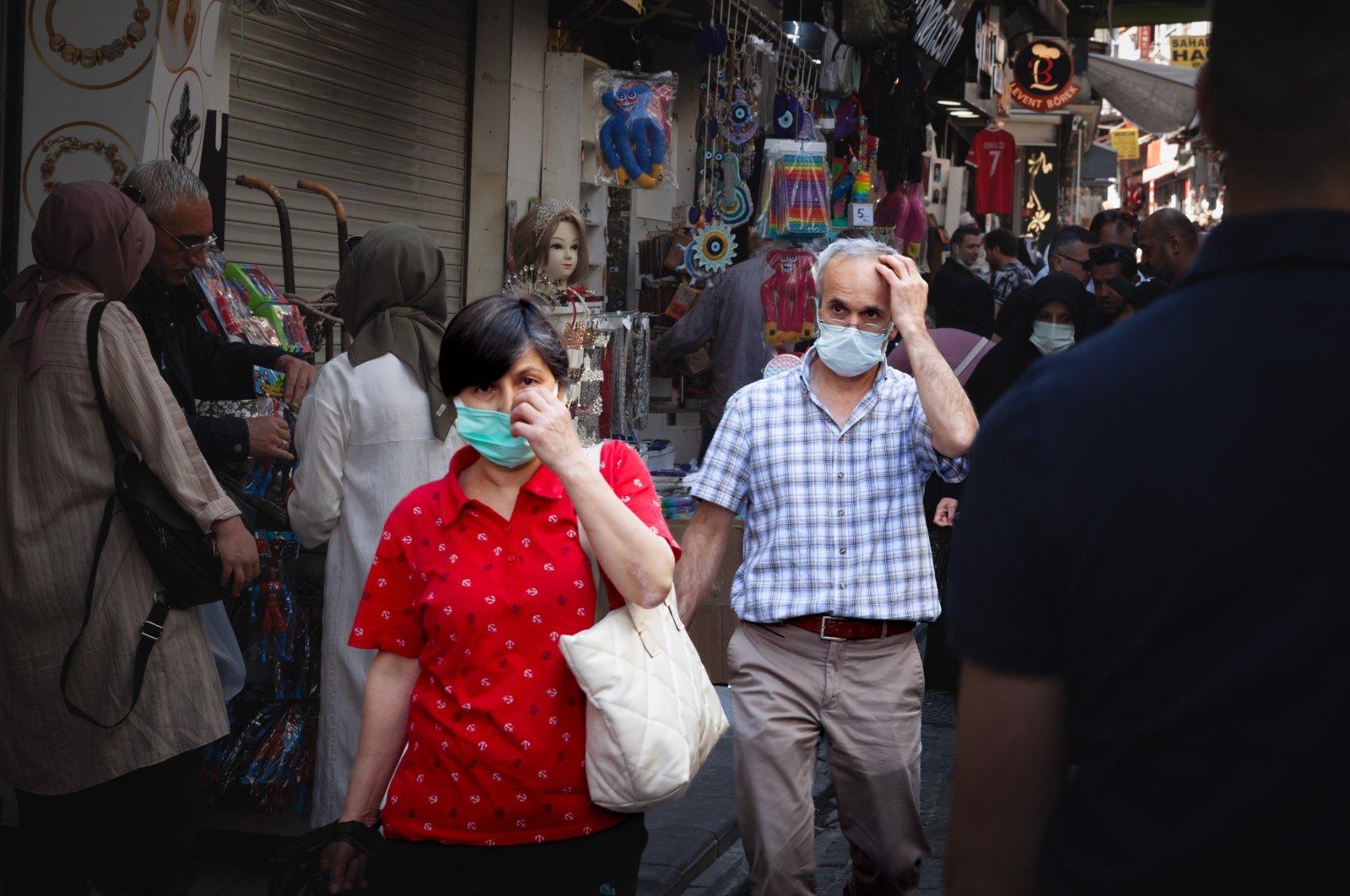 An elderly man and woman walk in a crowd during the COVID-19 outbreak, Istanbul, Türkiye, May 21, 2022. (Shutterstock Photo)