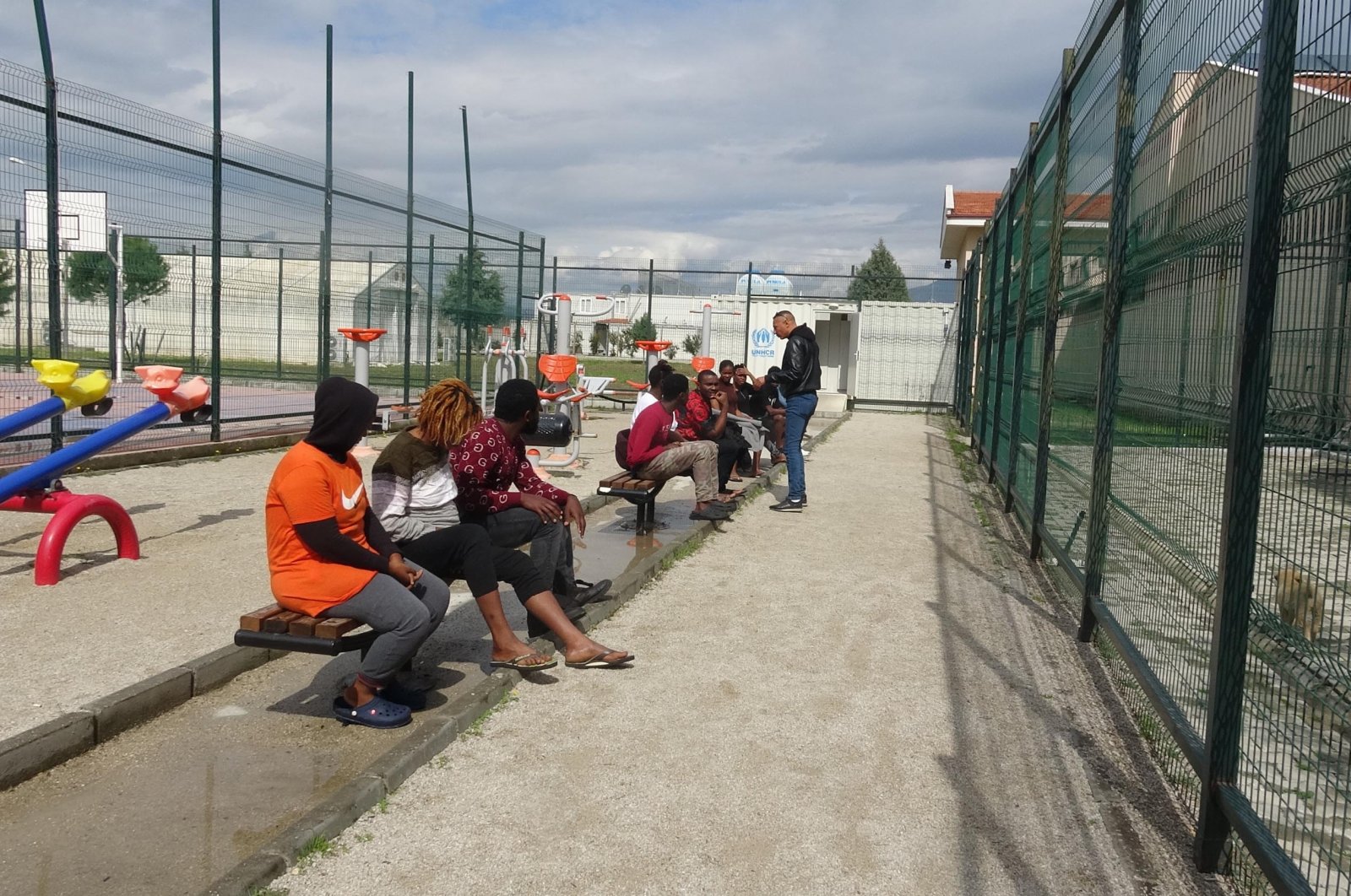 Migrants sit in a park outside a center for irregular migrants in Aydın, western Türkiye, March 17, 2023. (DHA Photo)