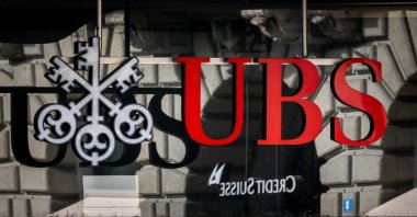 A photograph shows a logo of Swiss giant bank UBS in front of a logo of Credit Suisse bank in Zurich, Switzerland, March 19, 2023. (AFP Photo)