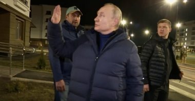 Russian President Vladimir Putin (C) waves at local residents during a visit to Mariupol in the Russia-controlled Donetsk region, Ukraine, March 19, 2023. (AP Photo)