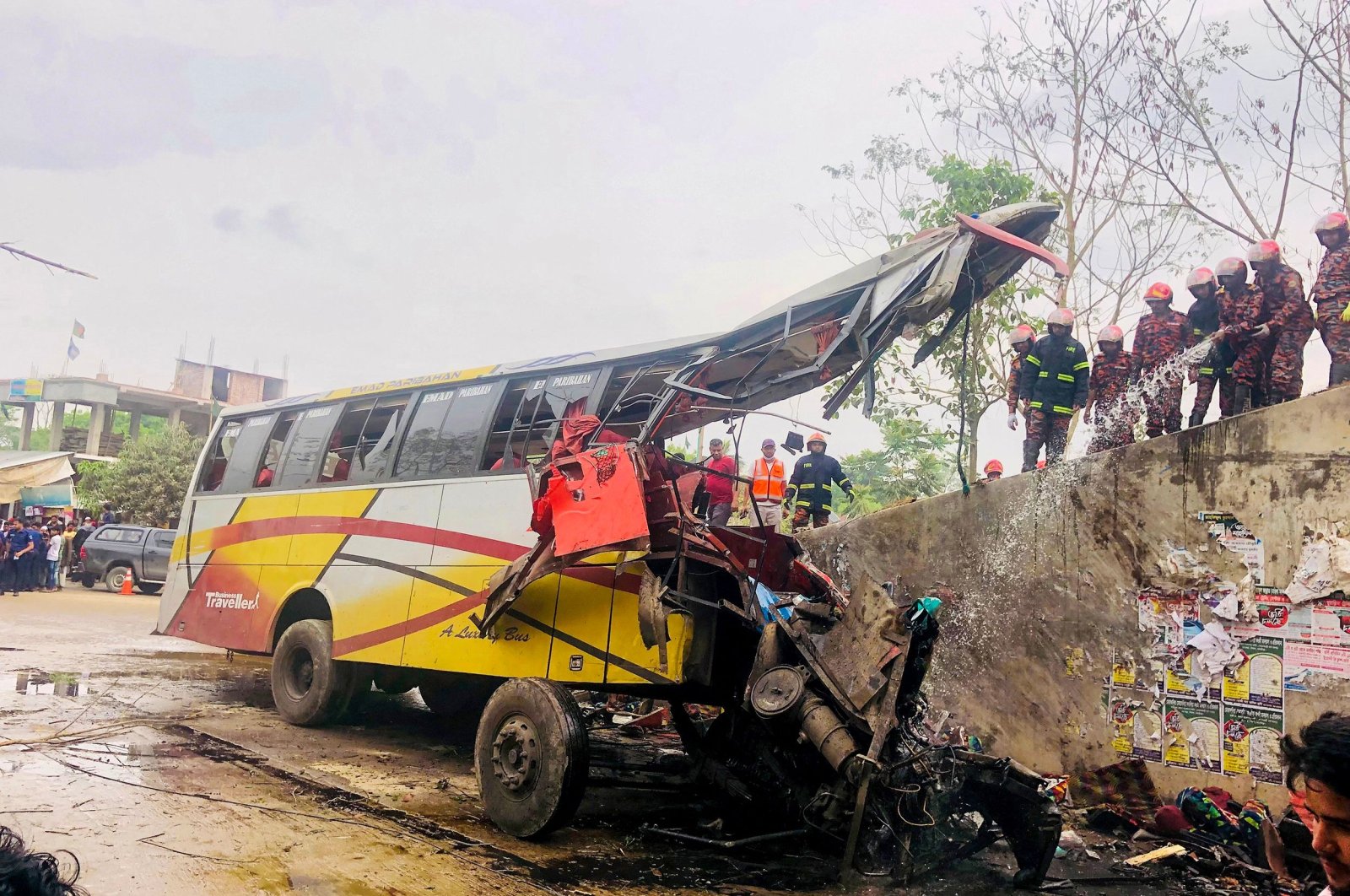 Firefighters at the scene of the bus accident that killed at least 19 people, in Shibchar, Madaripur, Bangladesh, March 19, 2023. (AFP Photo)