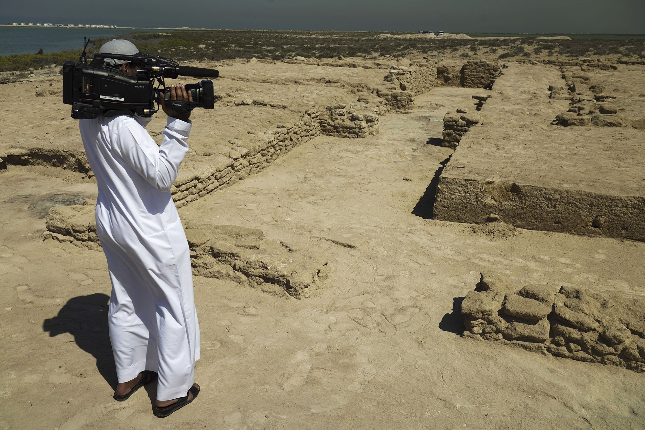 Журналист снимает обнаруженные руины на острове Синия в Умм-эль-Кувейне, Объединенные Арабские Эмираты, 20 марта 2023 года. (AP Photo)