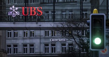 A traffic light signals green in front of the logos of the Swiss banks Credit Suisse and UBS in Zurich, Switzerland, March 19, 2023. ( AP Photo)