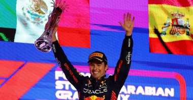 Red Bull's Sergio Perez celebrates with a trophy on the podium after winning the Saudi Arabian Grand Prix, Jeddah, Saudi Arabia, March 19, 2023. (Reuters Photo)