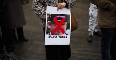 A woman holds a photograph of far-right activist Rasmus Paludan during a small protest outside the Swedish Consulate in Istanbul, Türkiye, Jan. 28, 2023. (AP File Photo)