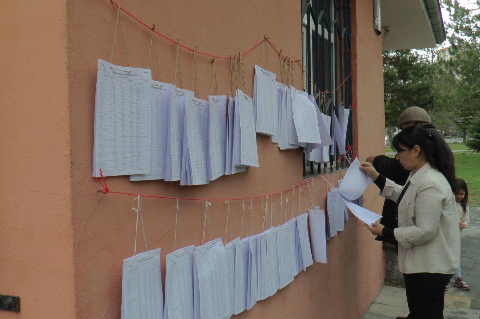 People check their names on official voter registry lists outside a public building in Kayseri, central Türkiye, March 20, 2023. (IHA Photo)