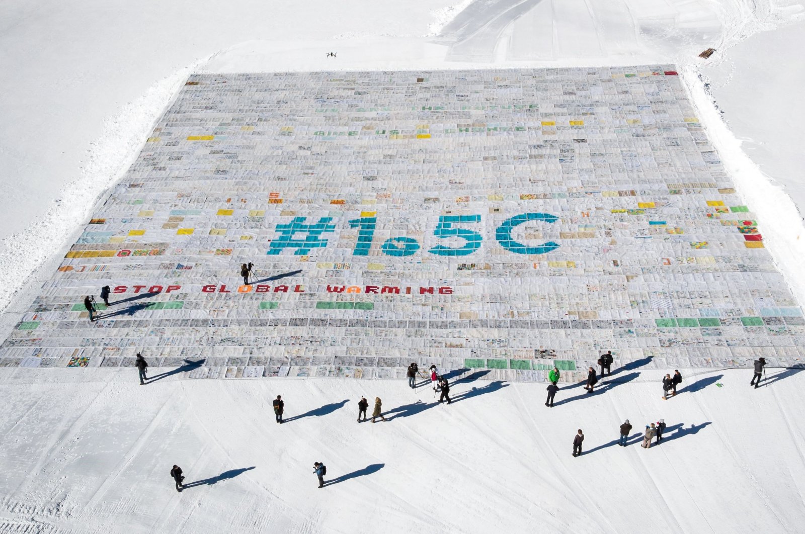 An aerial view shows a massive collage of 125,000 drawings and messages from children from around the world about climate change rolled out on the Aletsch Glacier, near the Jungfraujoch in the Swiss Alps, Switzerland, Nov. 16, 2018. (AFP Photo)