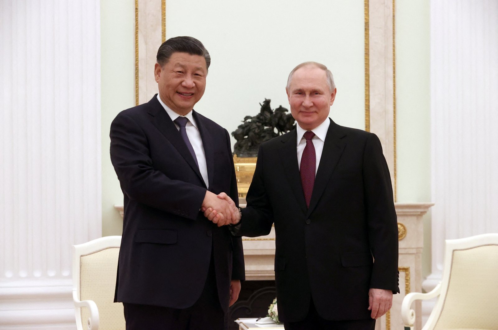 Russian President Vladimir Putin (R) and Chinese President Xi Jinping shake hands during a meeting at the Kremlin, Moscow, Russia, March 20, 2023. (Sputnik/Sergei Karpukhin/Pool via Reuters)