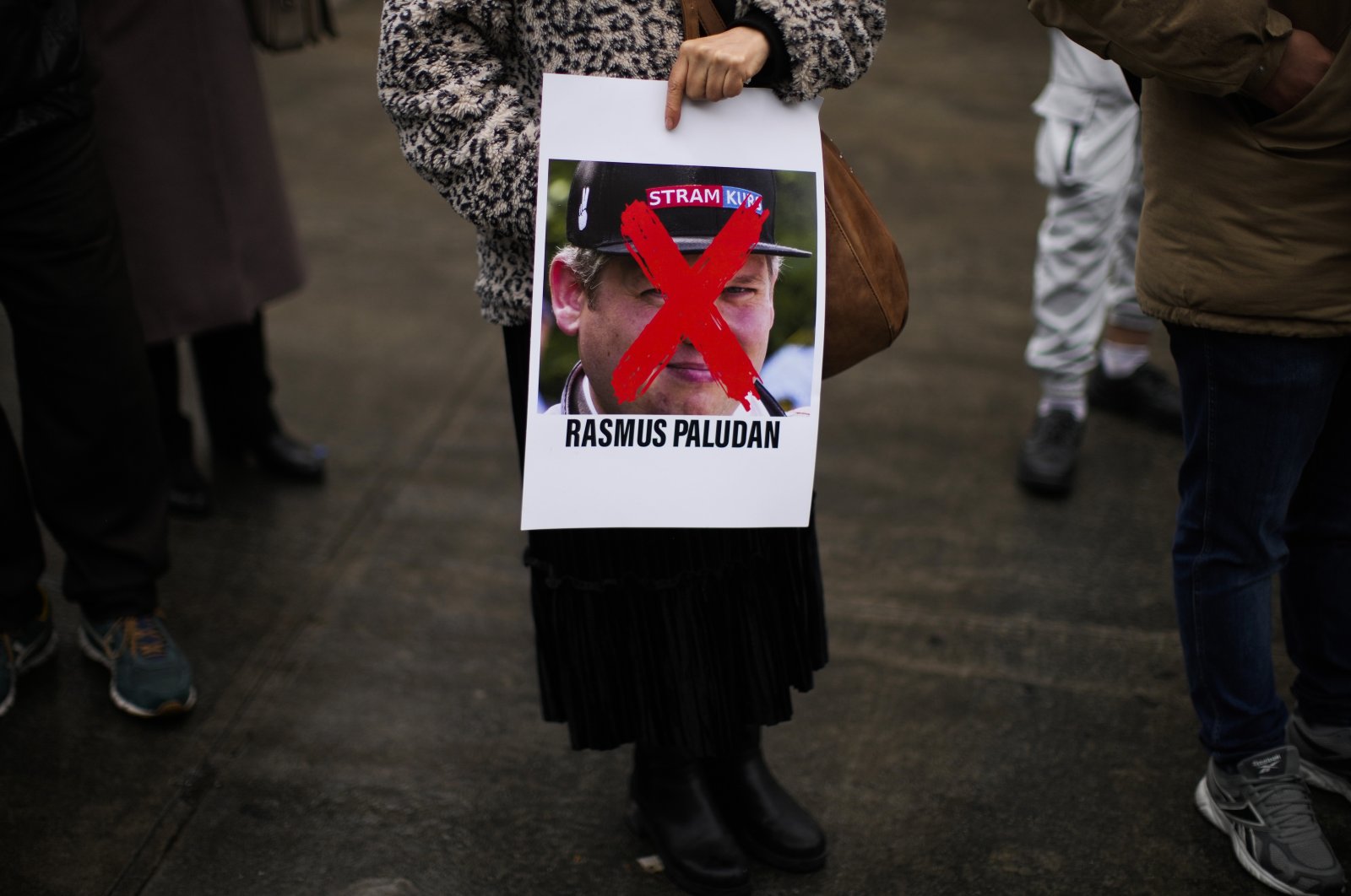 A woman holds a photograph of far-right activist Rasmus Paludan during a small protest outside the Swedish Consulate in Istanbul, Türkiye, Jan. 28, 2023. (AP File Photo)