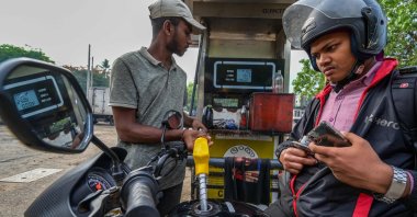 A worker fills petrol in a motorbike at a fuel station on March 21, 2023. - Sri Lanka must not allow entrenched corruption to undermine a bailout for its bankrupt economy, the IMF said on March 21, 2023, after signing off on a $3 billion loan for the crisis-hit nation. (AFP Photo)