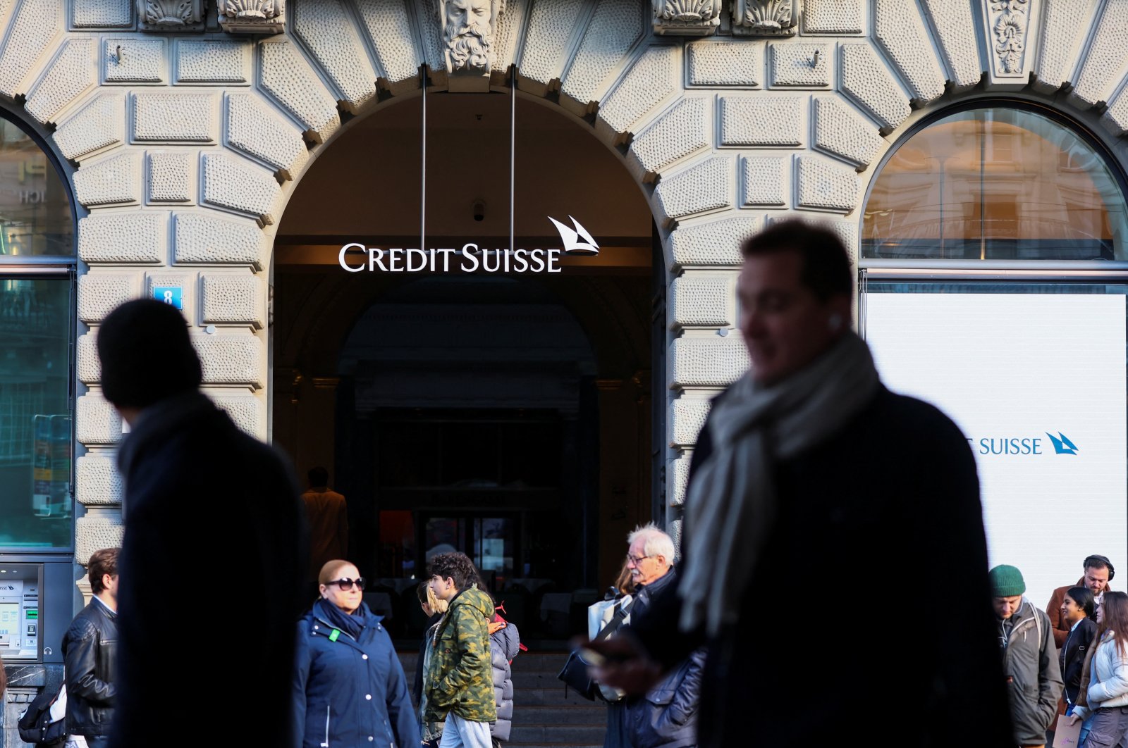 People walk near the logo of the Swiss bank Credit Suisse in Zurich, Switzerland, March 20, 2023. (Reuters Photo)
