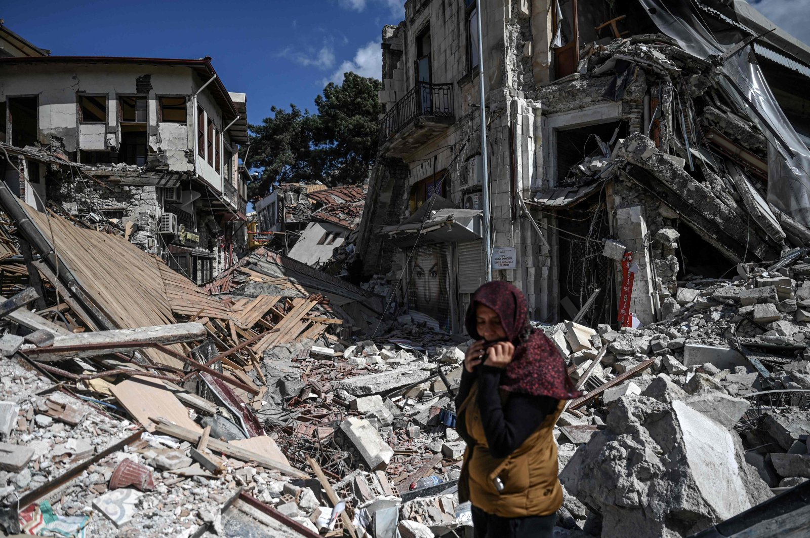 A woman stands among the rubble of collapsed buildings in Hatay, southern Türkiye, March 6, 2023. (AFP Photo)