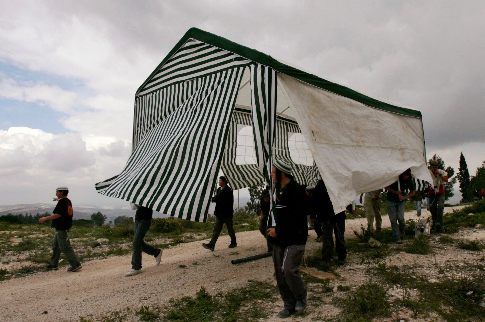 Israeli activists carry a tent in the abandoned Jewish settlement of Homesh, northern West Bank, March 27, 2007. (Reuters Photo)