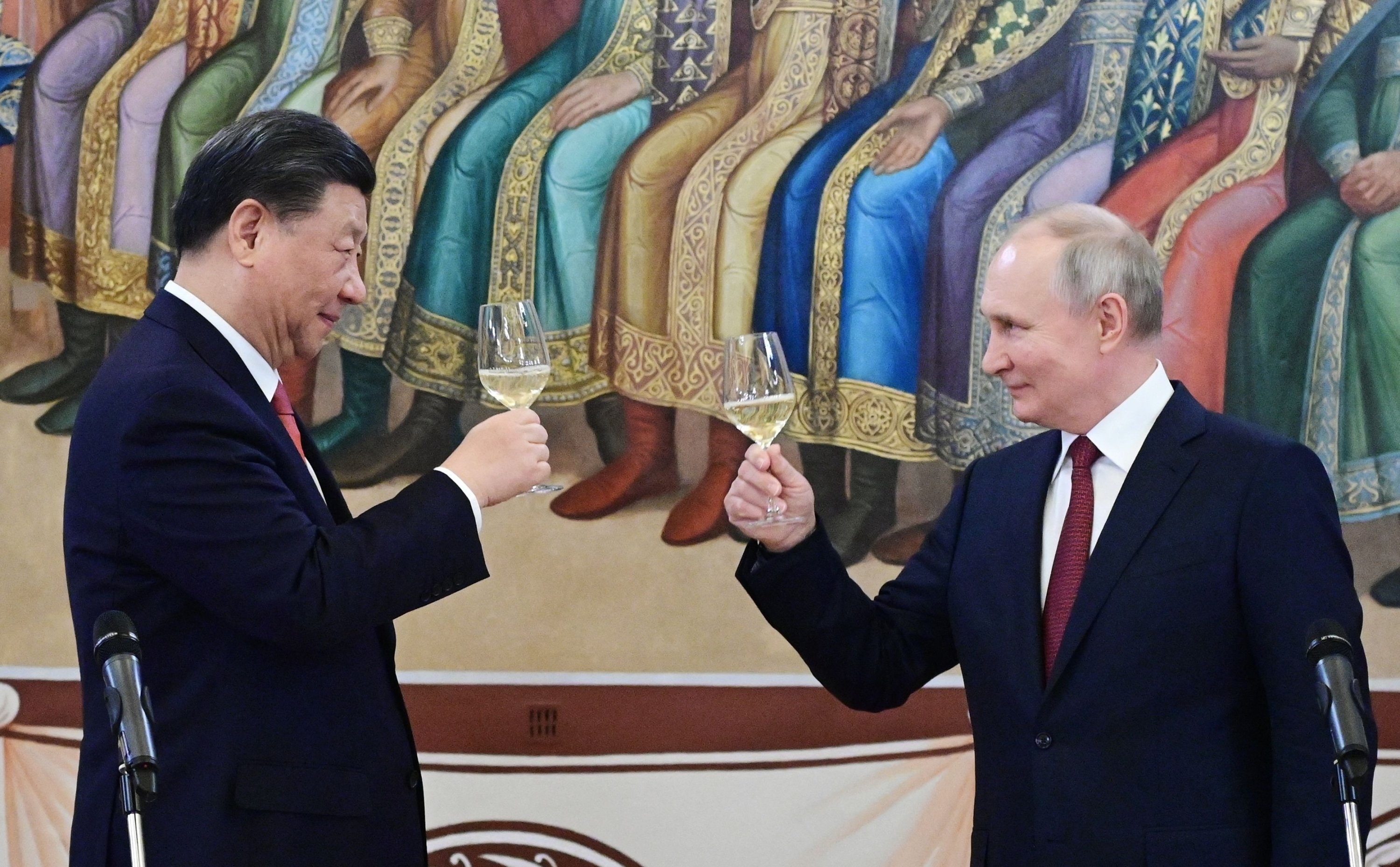 Presiden Rusia Vladimir Putin (kanan) dan Presiden China Xi Jinping bersulang saat resepsi di Moskow, Rusia, 21 Maret 2023. (AFP Photo)