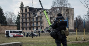 A police officer stands guard as rescuers work at a site of a building heavily damaged by a Russian drone strike, Rzhyshchiv, Kyiv region, Ukraine, March 22, 2023. (Reuters Photo)