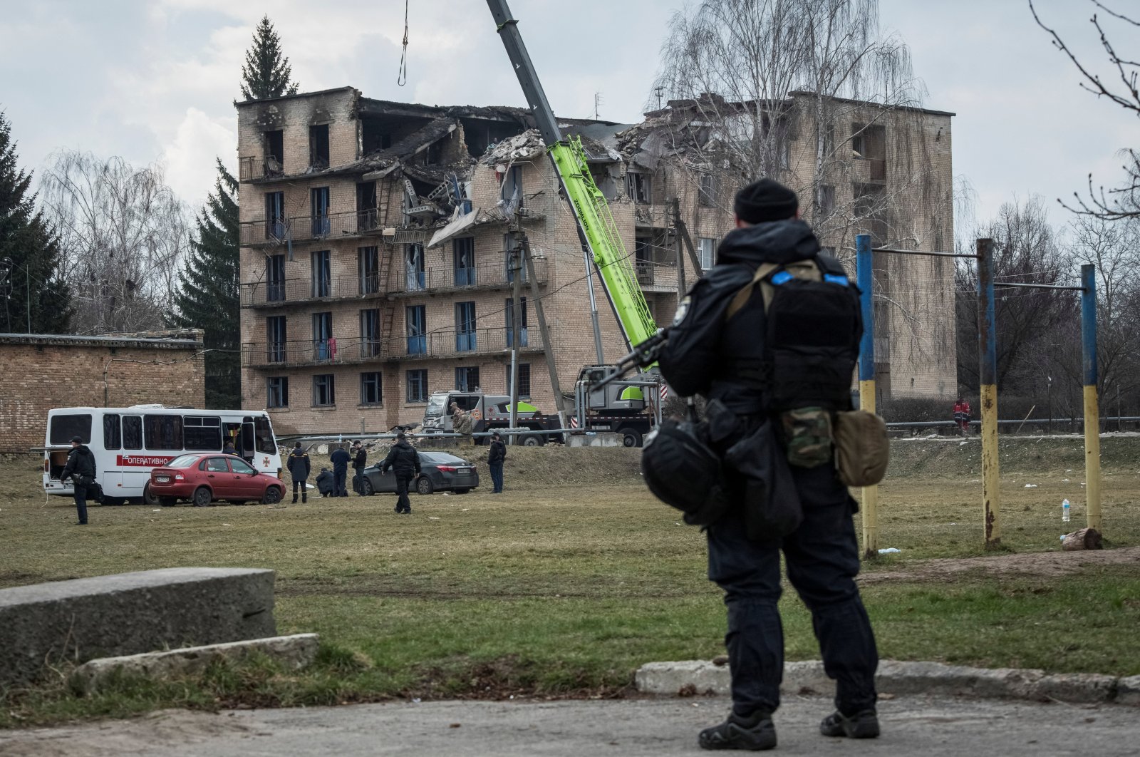 A police officer stands guard as rescuers work at a site of a building heavily damaged by a Russian drone strike, Rzhyshchiv, Kyiv region, Ukraine, March 22, 2023. (Reuters Photo)