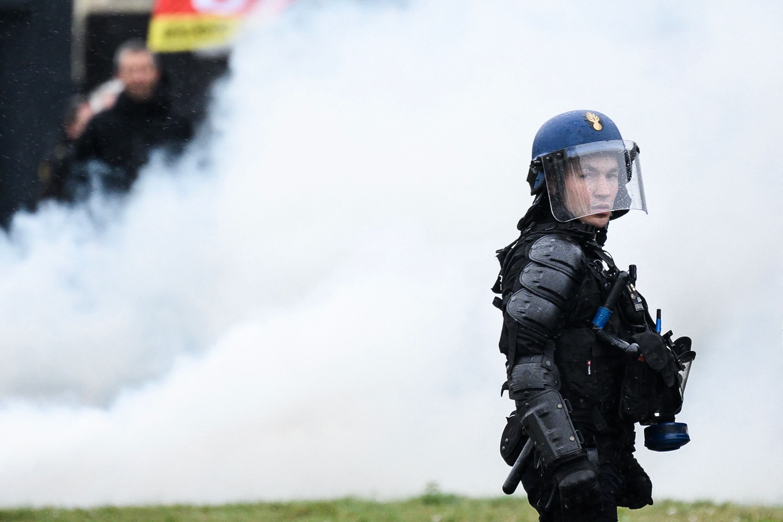 Polisi Prancis berdiri di samping asap saat demonstrasi di Nantes, Prancis barat, 23 Maret 2023. (Foto AFP)