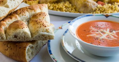Traditional Turkish Ramadan dinner iftar table with tomato soup and sliced Ramadan bread (pide). (Shutterstock Photo)