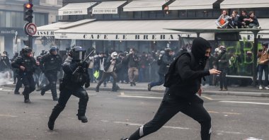 A protester runs from anti-riot police during a demonstration against the government pension reform, Paris, France, March 23, 2023. (EPA Photo)