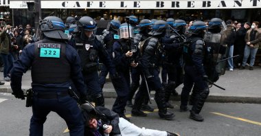 French riot police apprehend a protester amid clashes during a demonstration as part of the ninth day of nationwide strikes and protests against the French government's pension reform, Paris, France, March 23, 2023.  (Reuters Photo)