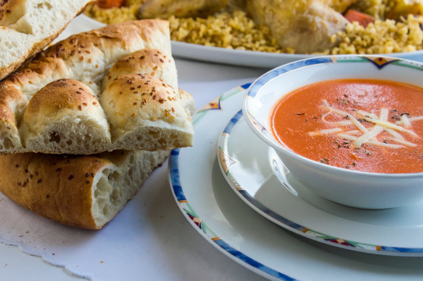 Traditional Turkish Ramadan dinner iftar table with tomato soup and sliced Ramadan bread (pide). (Shutterstock Photo)